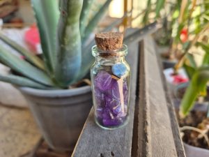 بطری شیشه ای شامل گوهرسنگ آمیتیست بنفش طبیعی